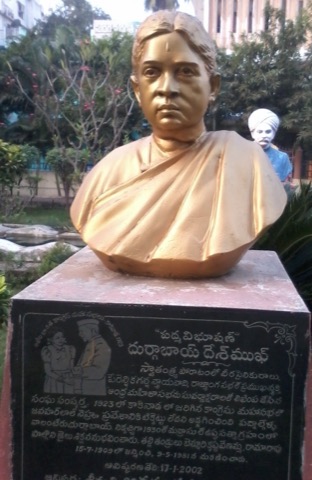 Gilded bronze bust of Durgabai Deshmukh on a plinth with a Telugu inscription.