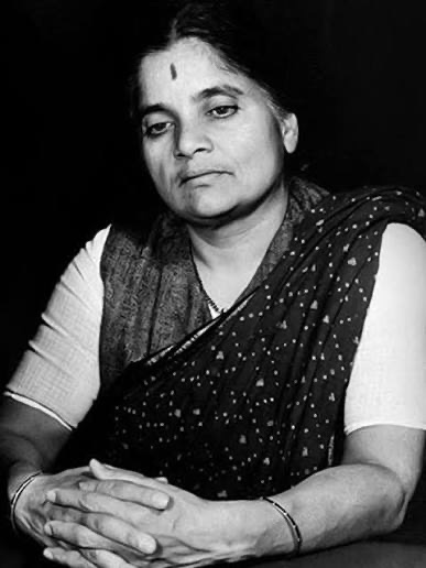 Photographic portrait of Durgabai Deshmukh seated with her hands folded, wearing a patterned sari.